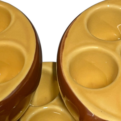close up of brown ceramic escargots dish with handles and a pale interior, on a white background.