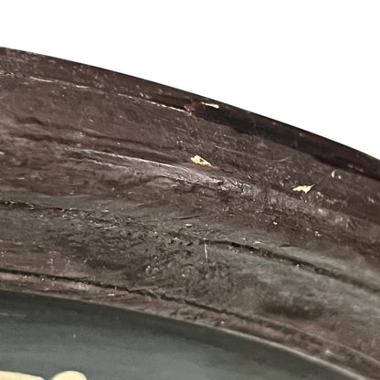 Corner of a framed picture with a dark brown frame and green interior.