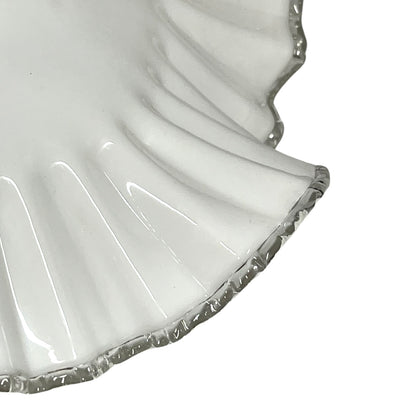 Close-up of a white lampshade with a scalloped edge on a white background