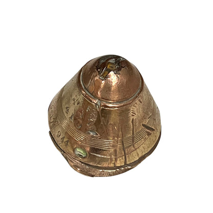 WW1 brass fuse paperweight with markings from use on a white background