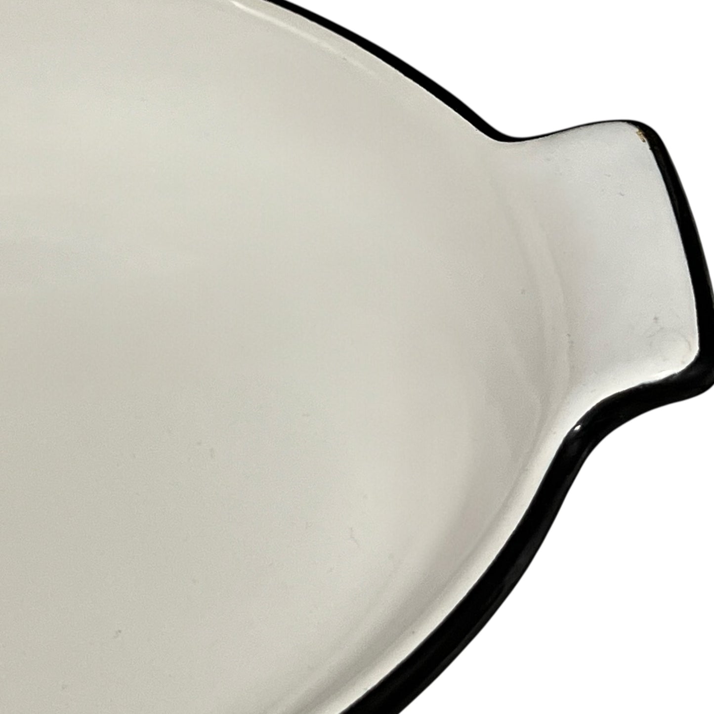 Close-up of a enamel baking dish with a black rim on a white background
