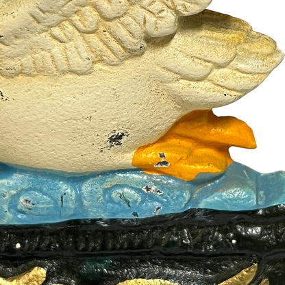 Close-up of a decorative sculptural object featuring a large textured cream-colored top section, a translucent light blue middle band, and a glossy black lower section with gold accents, against a white background.
