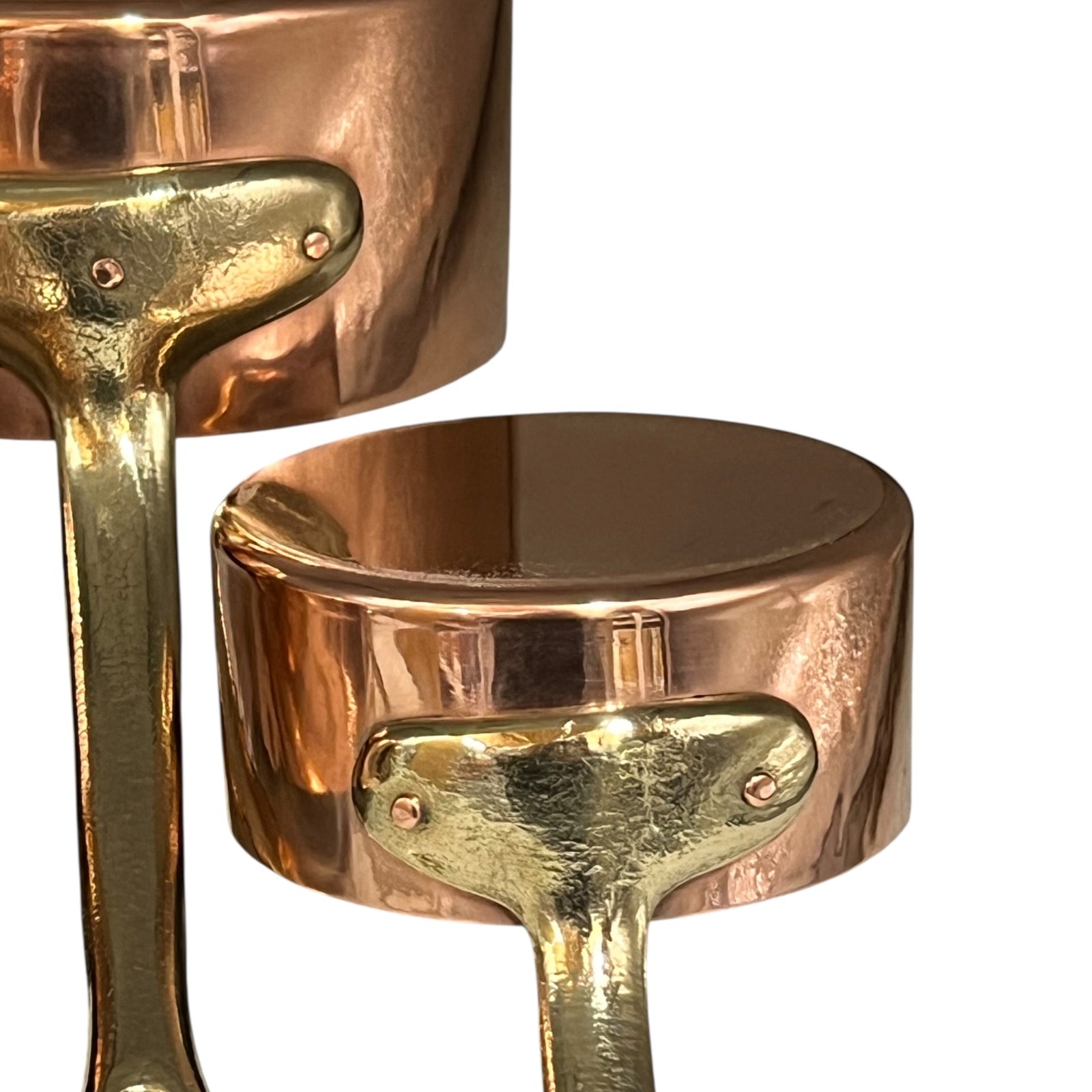 Close-up of a copper pot with a brass handle on a white background