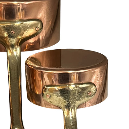 Close-up of a copper pot with a brass handle on a white background