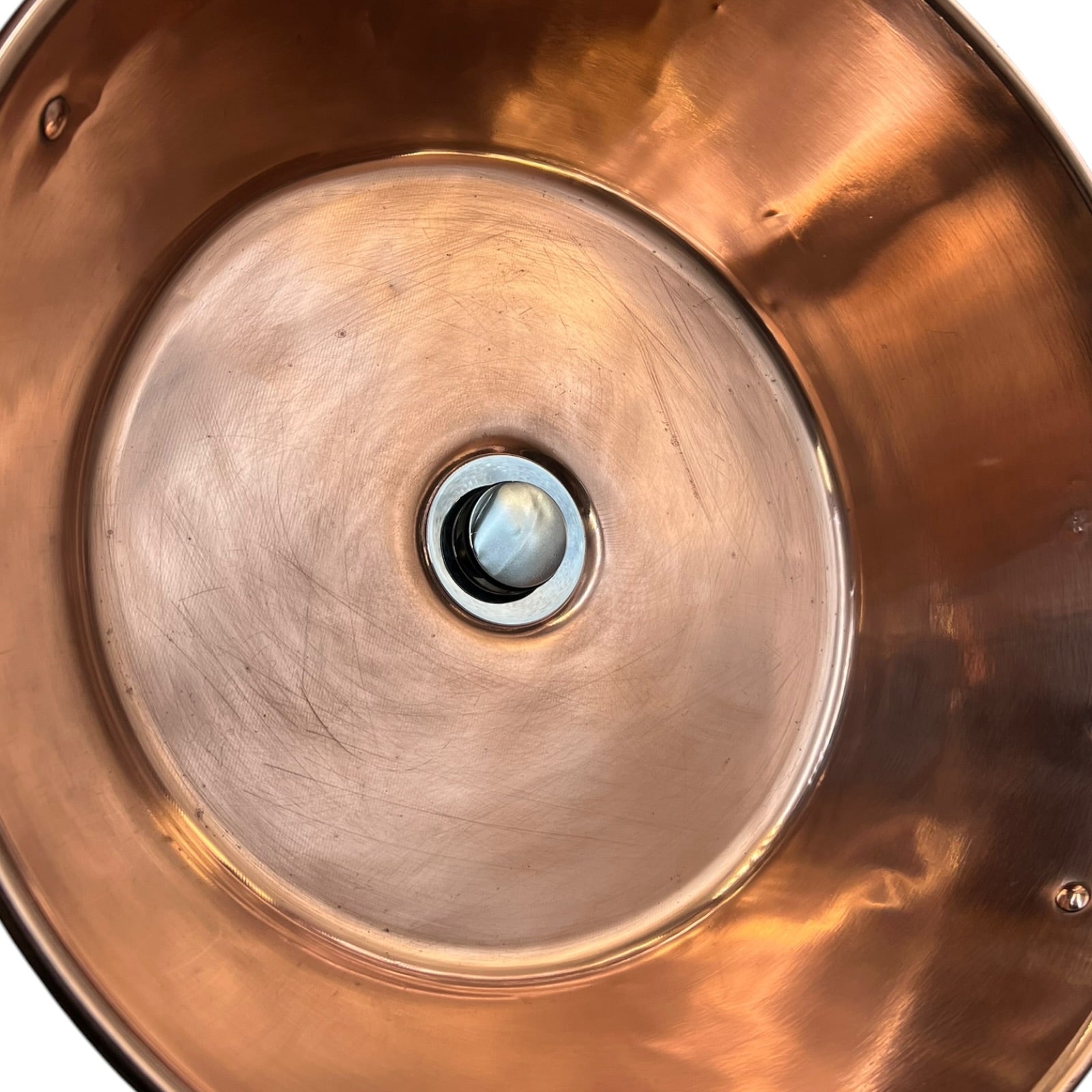 Close-up of a copper sink with a central drain