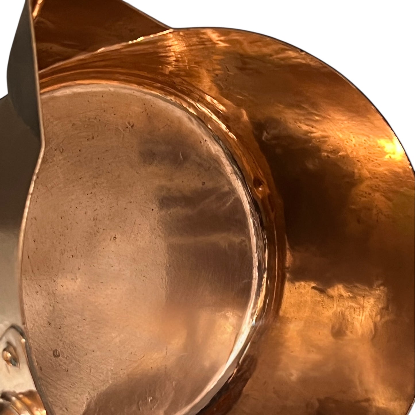 Close-up of a copper pot with a pouring spout on a white background