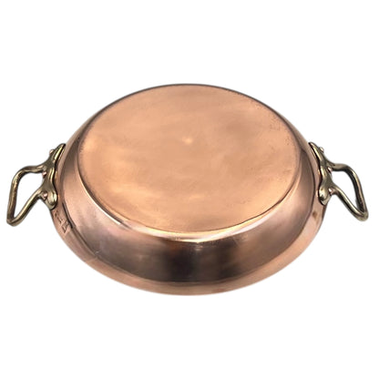 French copper round gratin pan with brass handles on a white background
