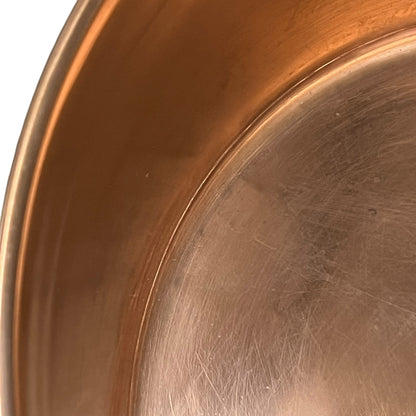 Close-up of a copper sink with a drain plug