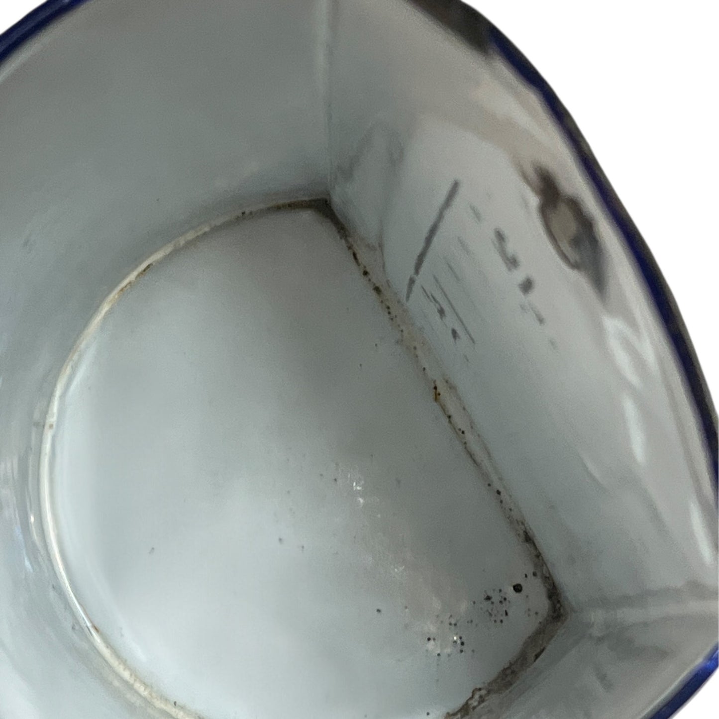 Close up of  French vintage enamel planter with a flat back and a spout on a white background