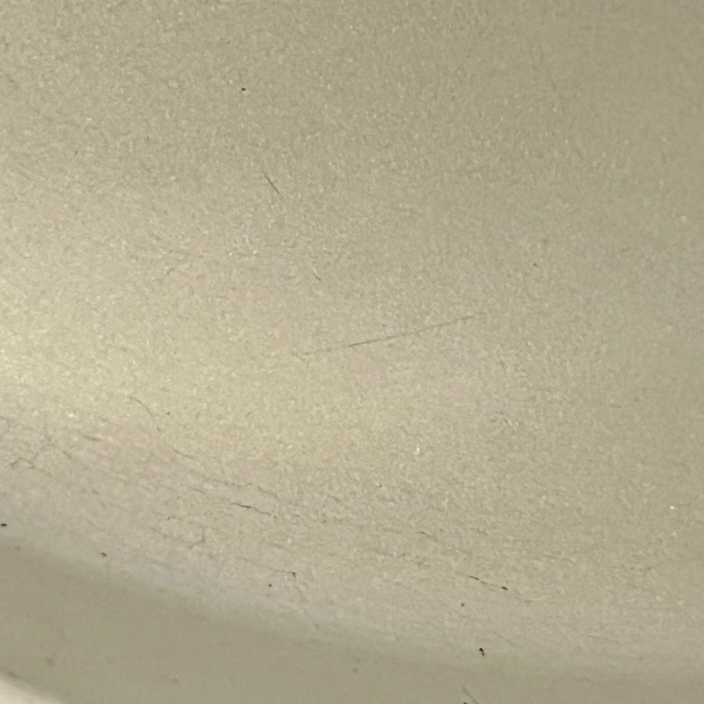 Close up of Le Creuset dish with beige interior on a white background