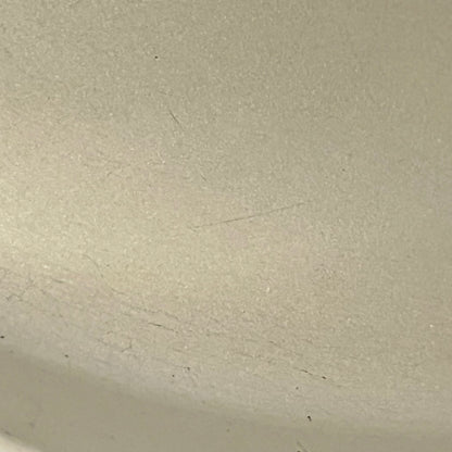 Close up of Le Creuset dish with beige interior on a white background