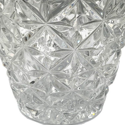 Close up of French cut glass ice bucket with textured design and metal handle on a white background 