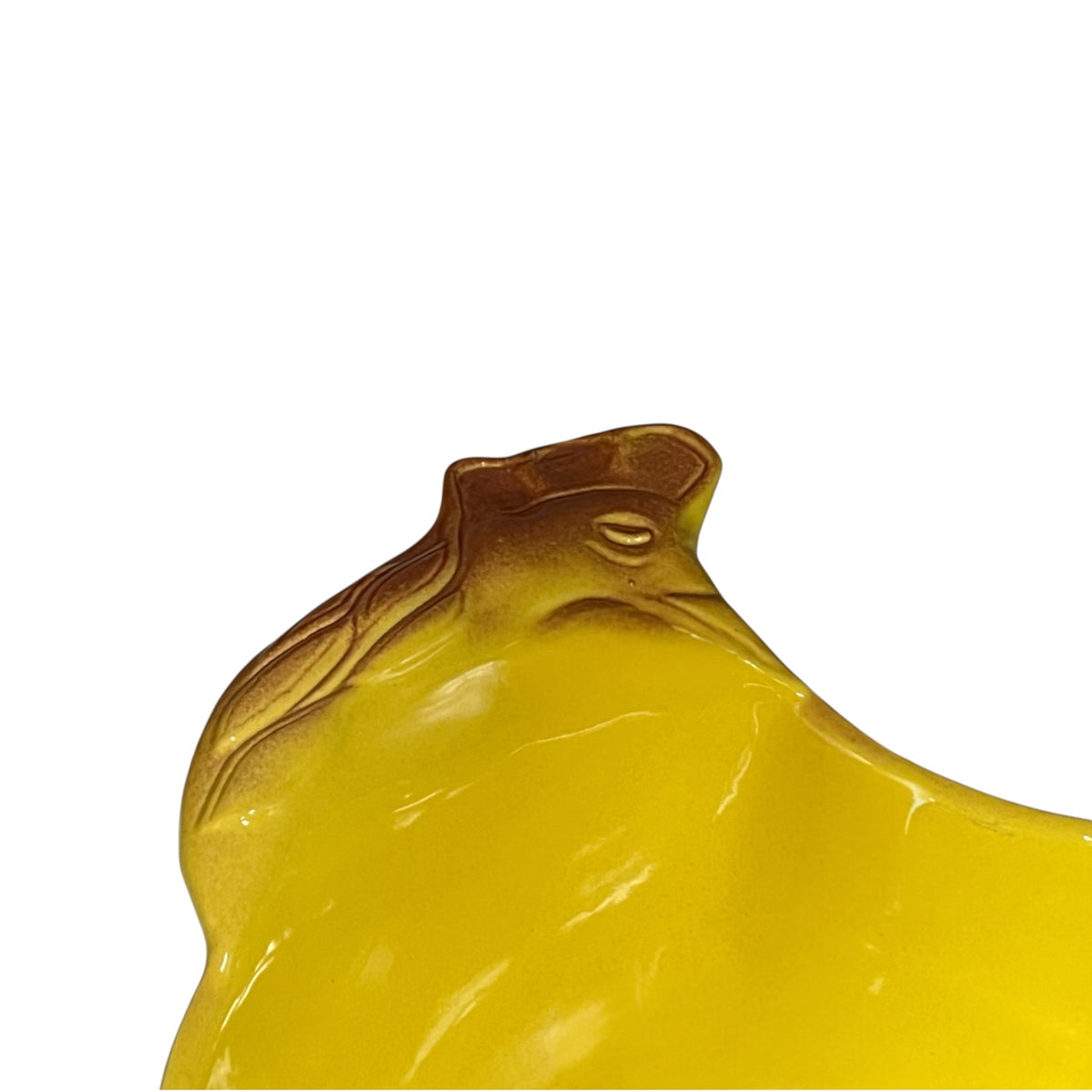 A close-up of a glossy translucent yellow chicken shaped bowl, shown against a plain white background.