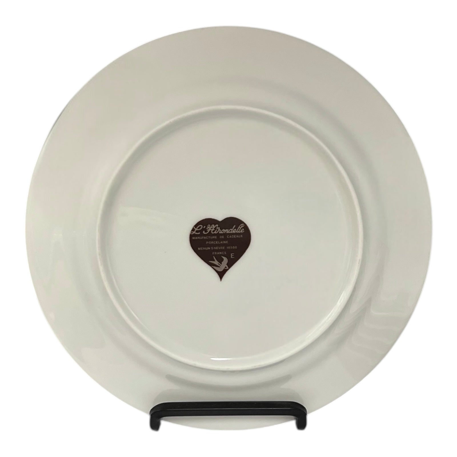 Back of a French cheese plate showing the Hirondelle makers stamp on a stand with a white background