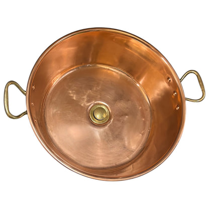 A copper sink with two side handles and a round central knob, photographed from above on a plain white background.