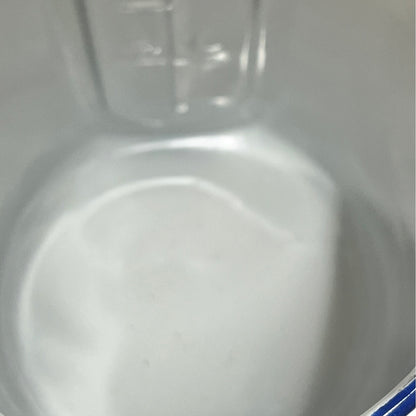 Close-up of the inside of a white enamel plant pot with a blue rim on a plain white background.