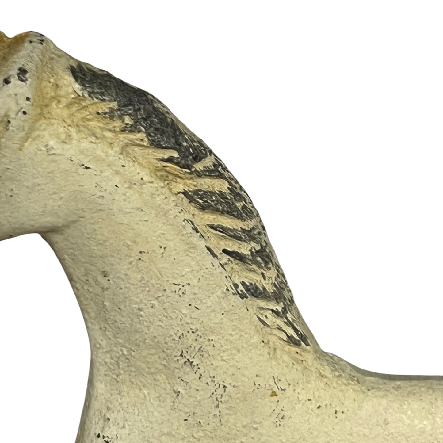 A close-up of a textured horse figurine showing its neck and shoulder, featuring a cream-colored body with a black painted mane, isolated on a white background.