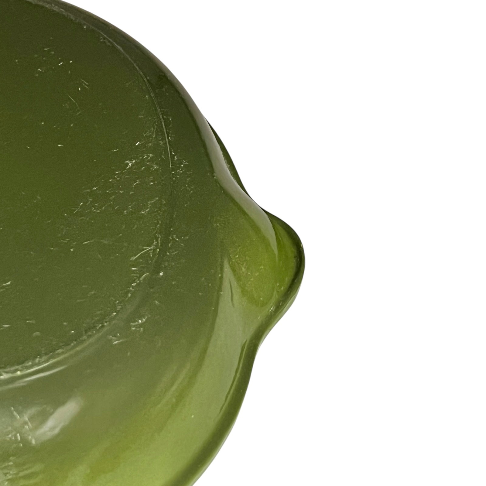 Close-up of a green Le Creuset cast iron skillet on a white background 