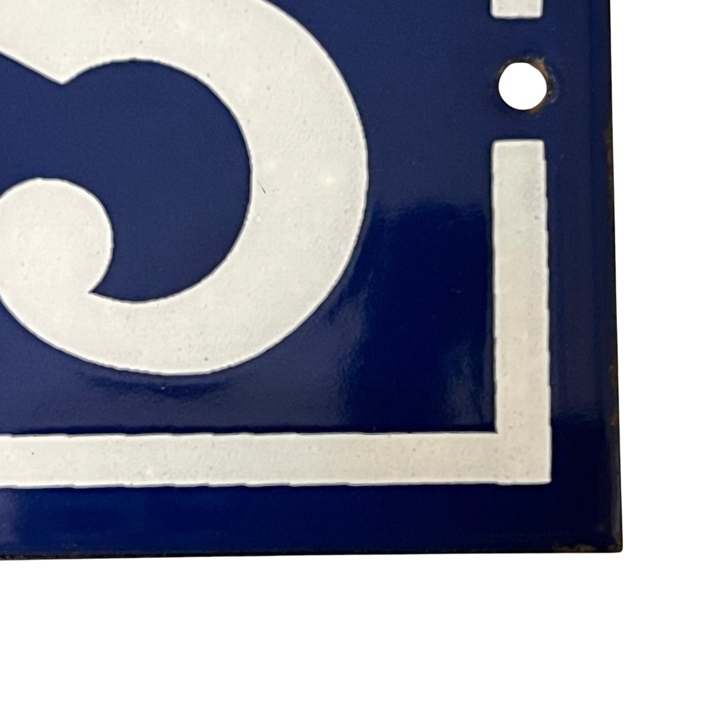 Close up of blue and white door number 65 on a white background 