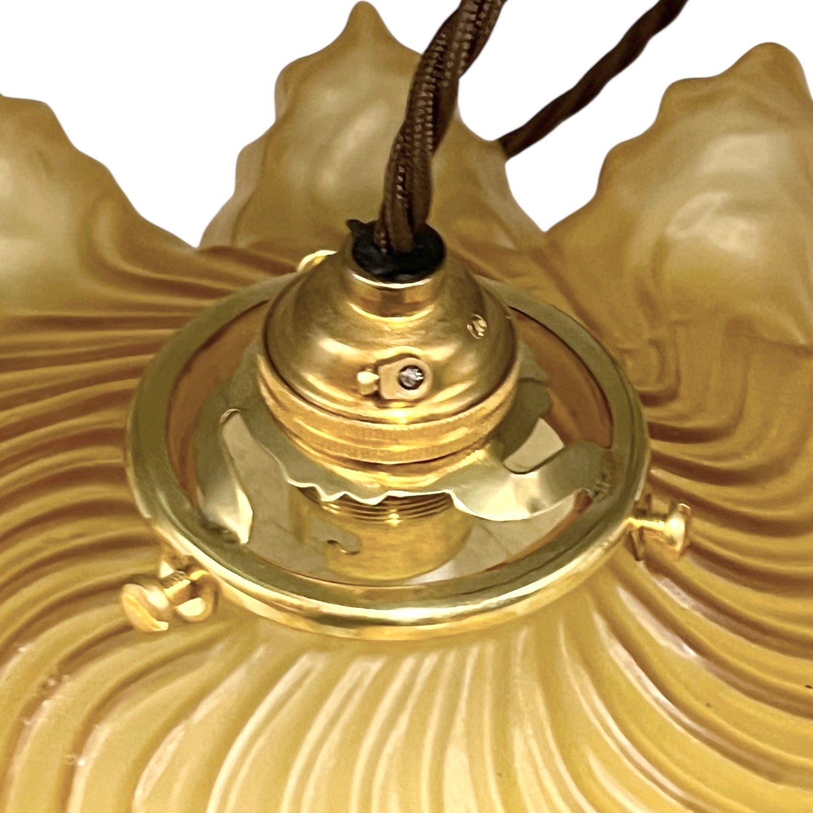close up of amber coloured vintage French  pendant light with a scalloped design on a white background