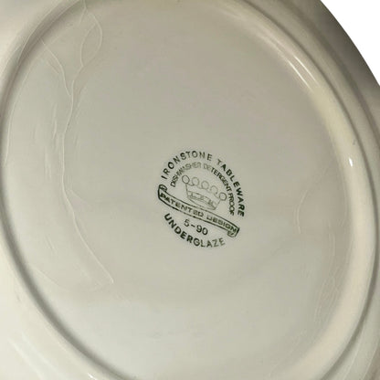 Close-up of a white ceramic plate with 'Ironstone Tableware' branding on a plain background.