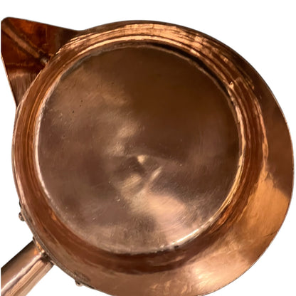 Close-up of a copper pot with a pouring spout on a white background