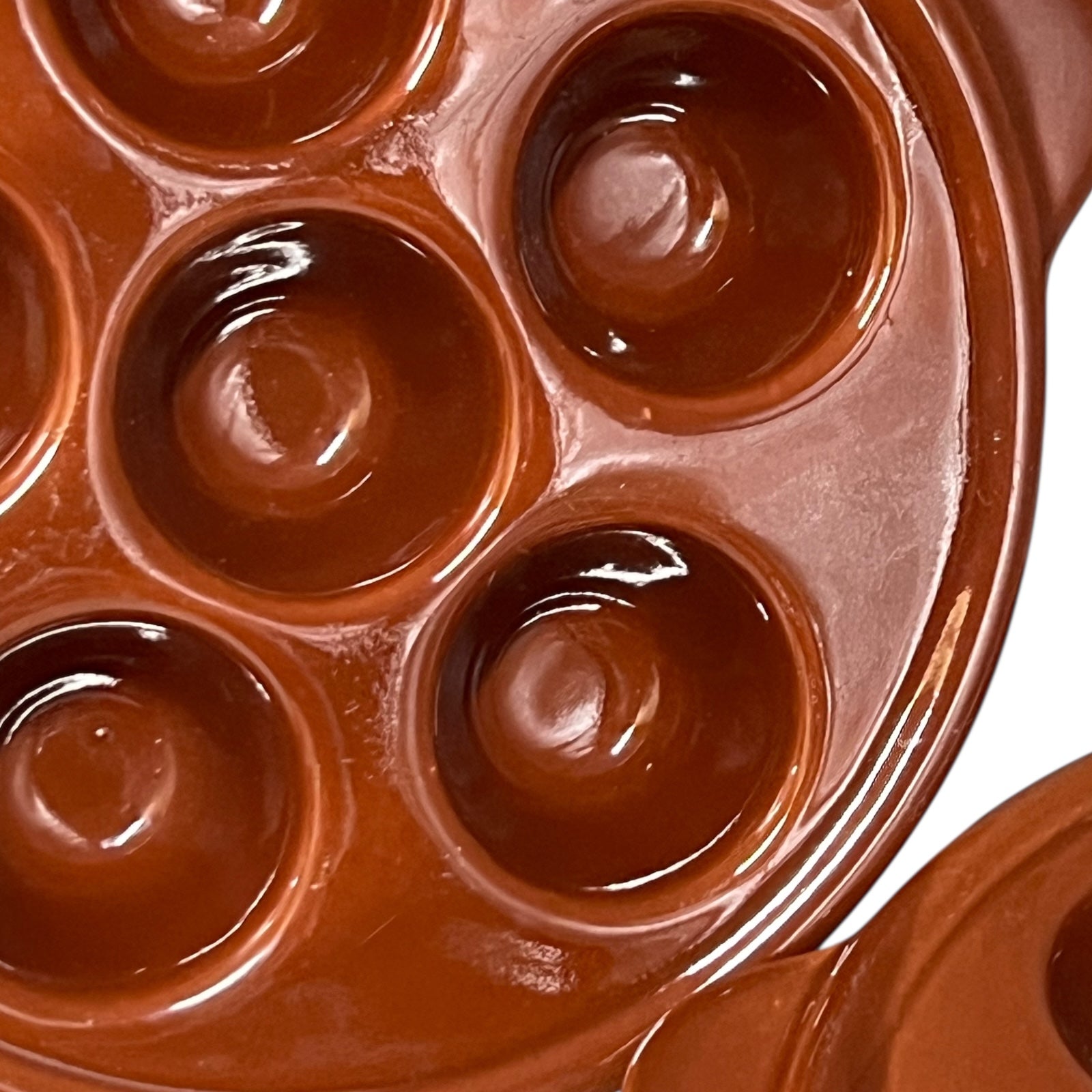 Brown ceramic egg ,snail, or escargots plates with multiple compartments on a white background