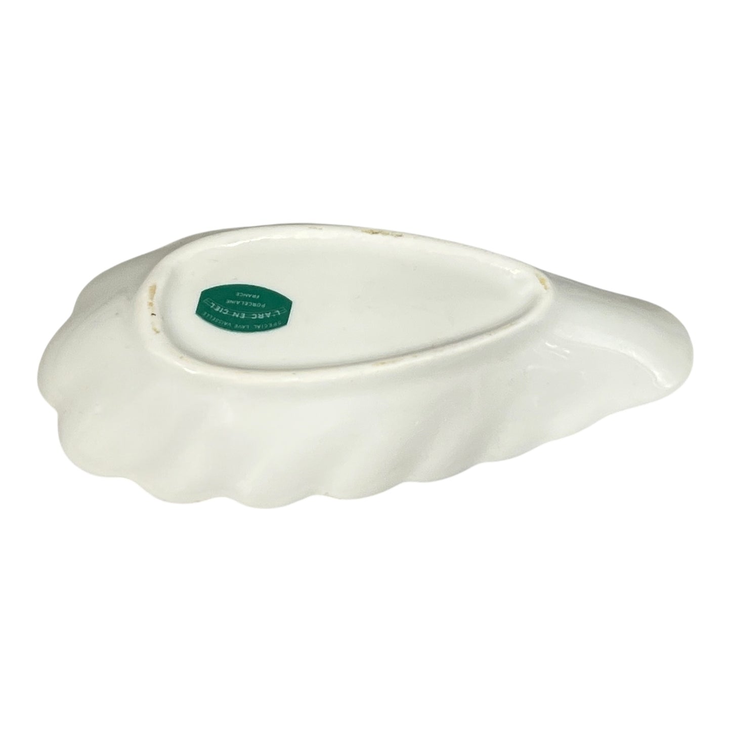 White ceramic dish with a green label on a white background