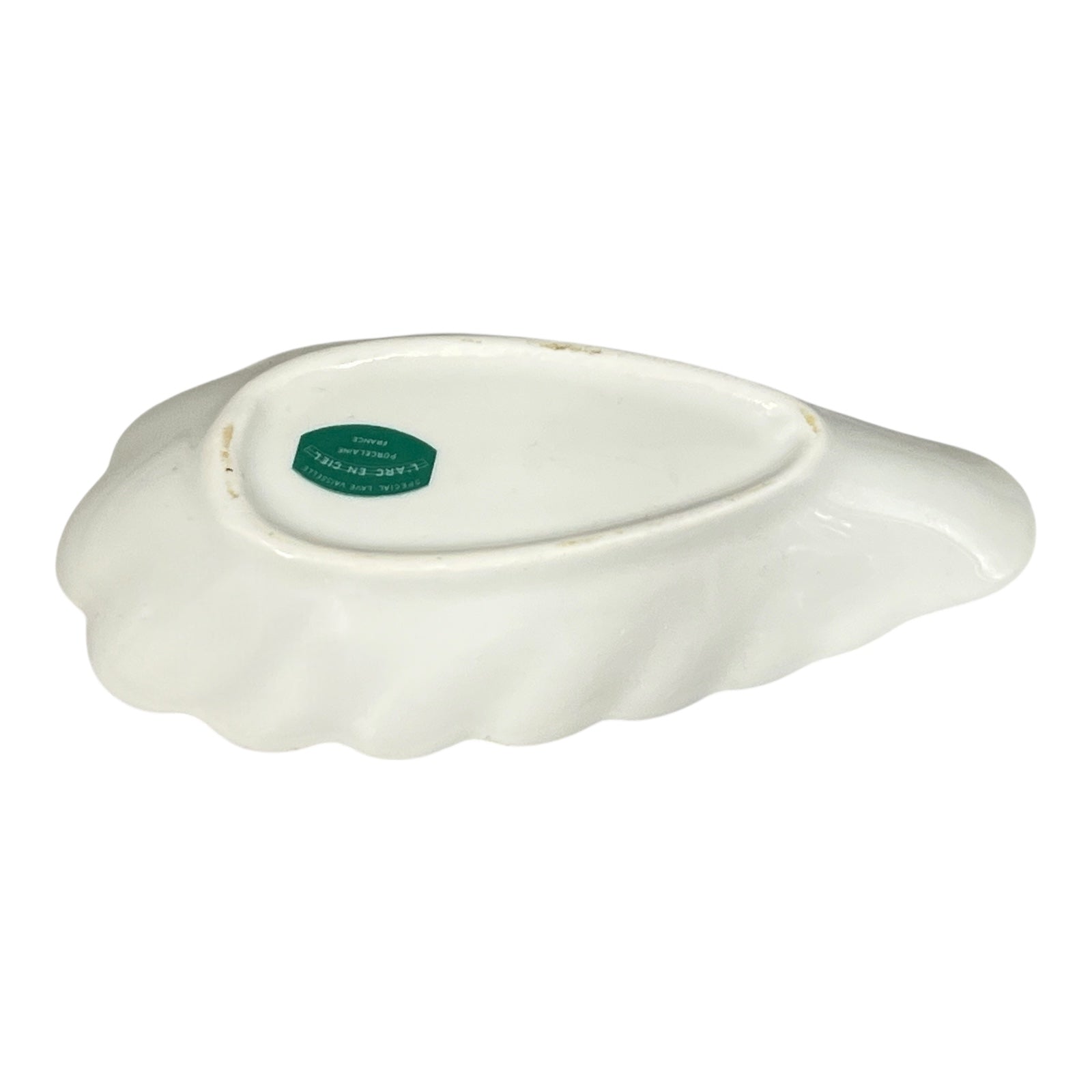 White ceramic dish with a green label on a white background
