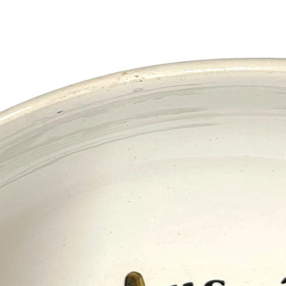 Close-up of a white ceramic plate with visible texture and branding.