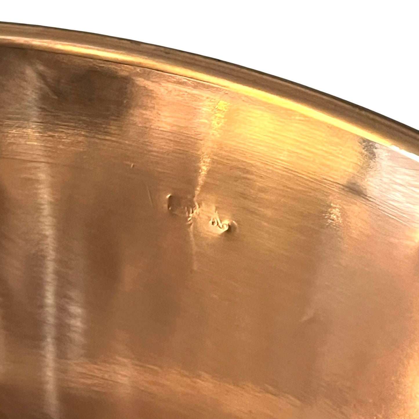 Close-up of a copper basin with a reflective finish on a white background 