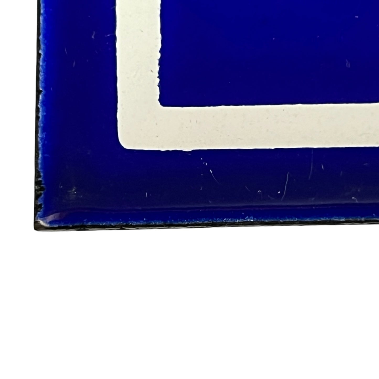 Close-up of a blue and white geometric patterned surface, showing a deep cobalt blue area with a thick white corner border.