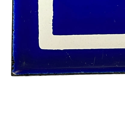 Close-up of a blue and white geometric patterned surface, showing a deep cobalt blue area with a thick white corner border.