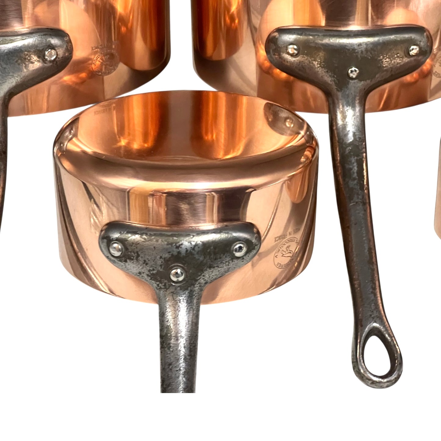 Close-up of copper cookware with iron handles on a white background