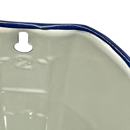 Close-up of a white planter with a blue rim on a white background