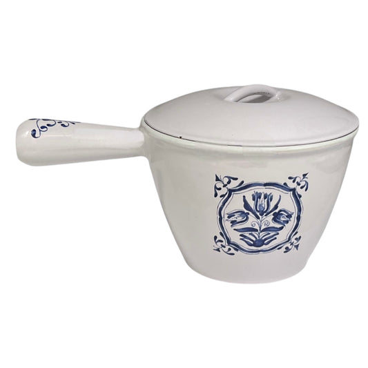 White enamelled cast iron pot with blue floral design and handle on a white background