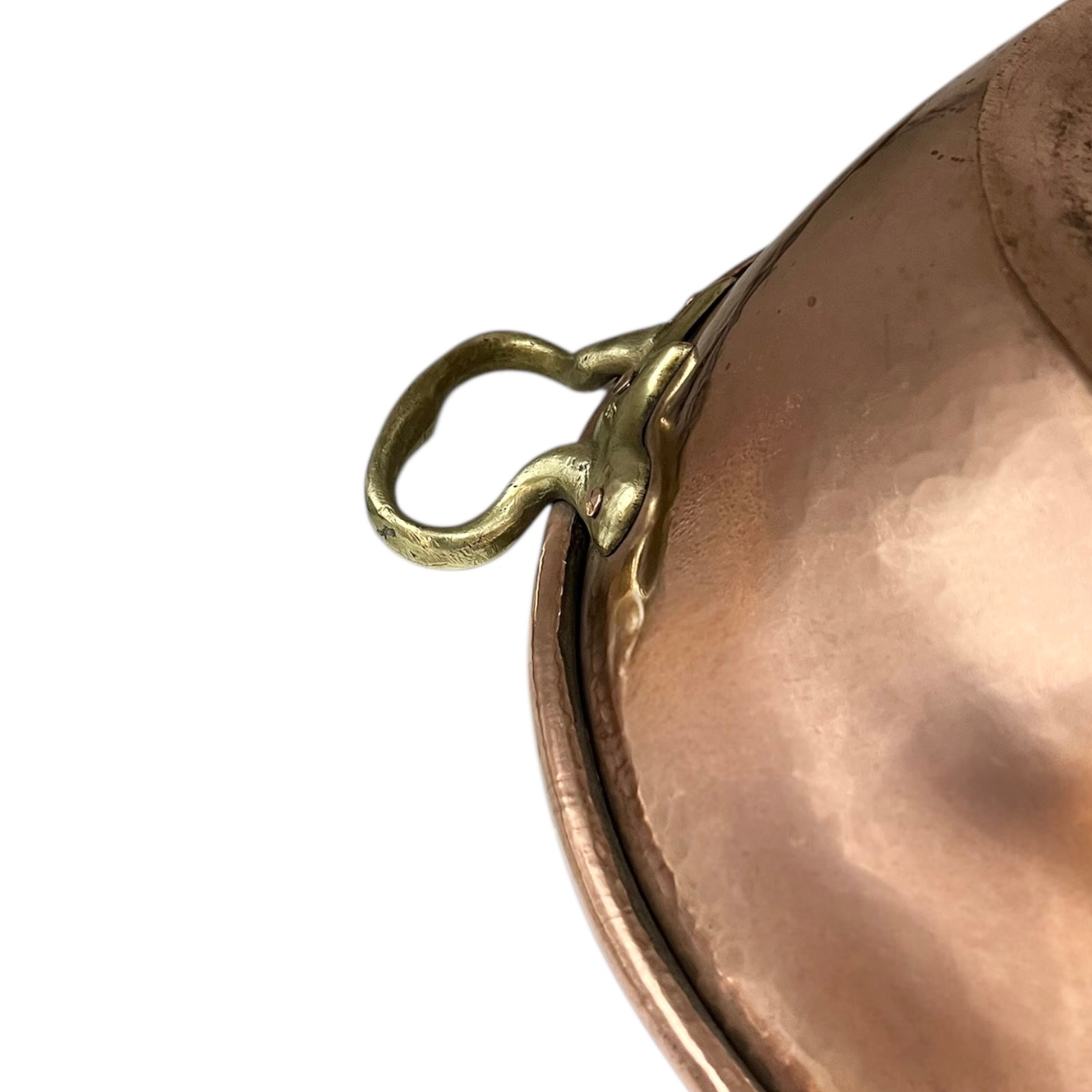 Close-up of a bronze or copper pot with a brass handle on a white background