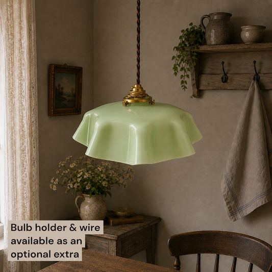French vintage pale green milk glass light with brown twisted wiring and brass fittings hanging from a ceiling in a rustic farmhouse setting 