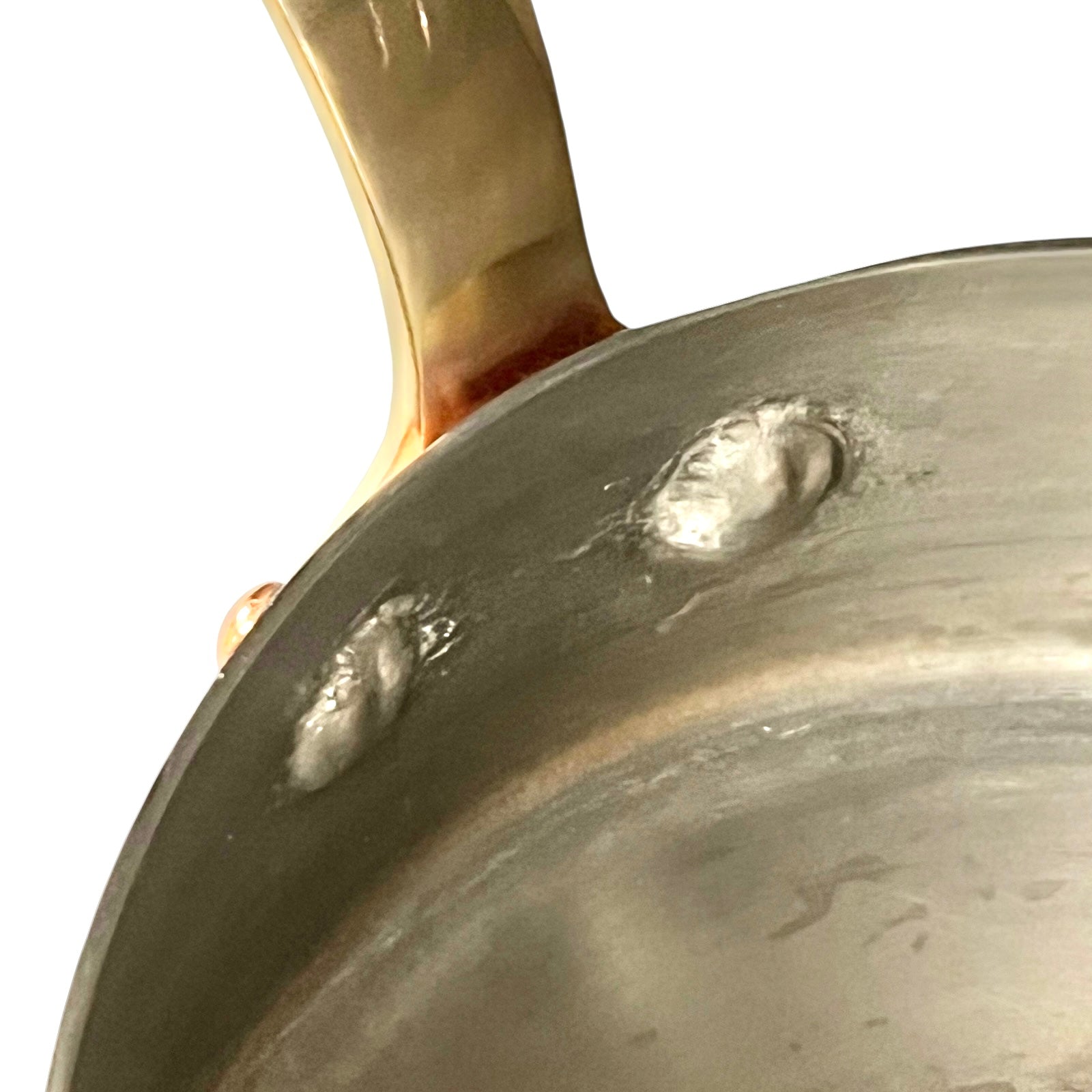 Small copper frying pan with a brass handle and tin lining on a white background