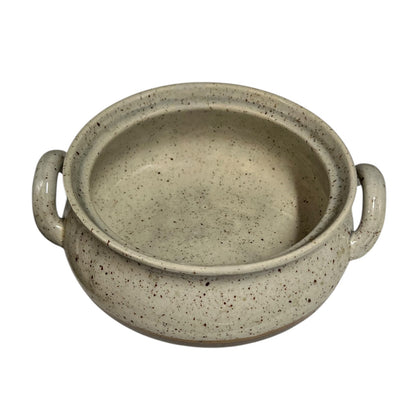Close up of a speckled ceramic container on a white background