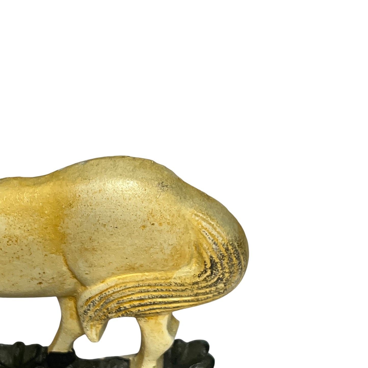 Close-up of the rear and tail of a small animal figurine, likely a rabbit or hare, in a textured cream and gold finish, standing on a dark base against a plain white background.