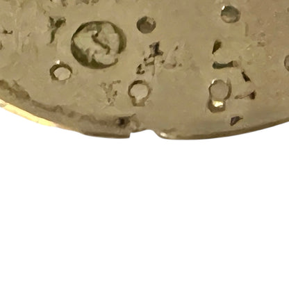 Close-up of a gold object with engraved text on a white background