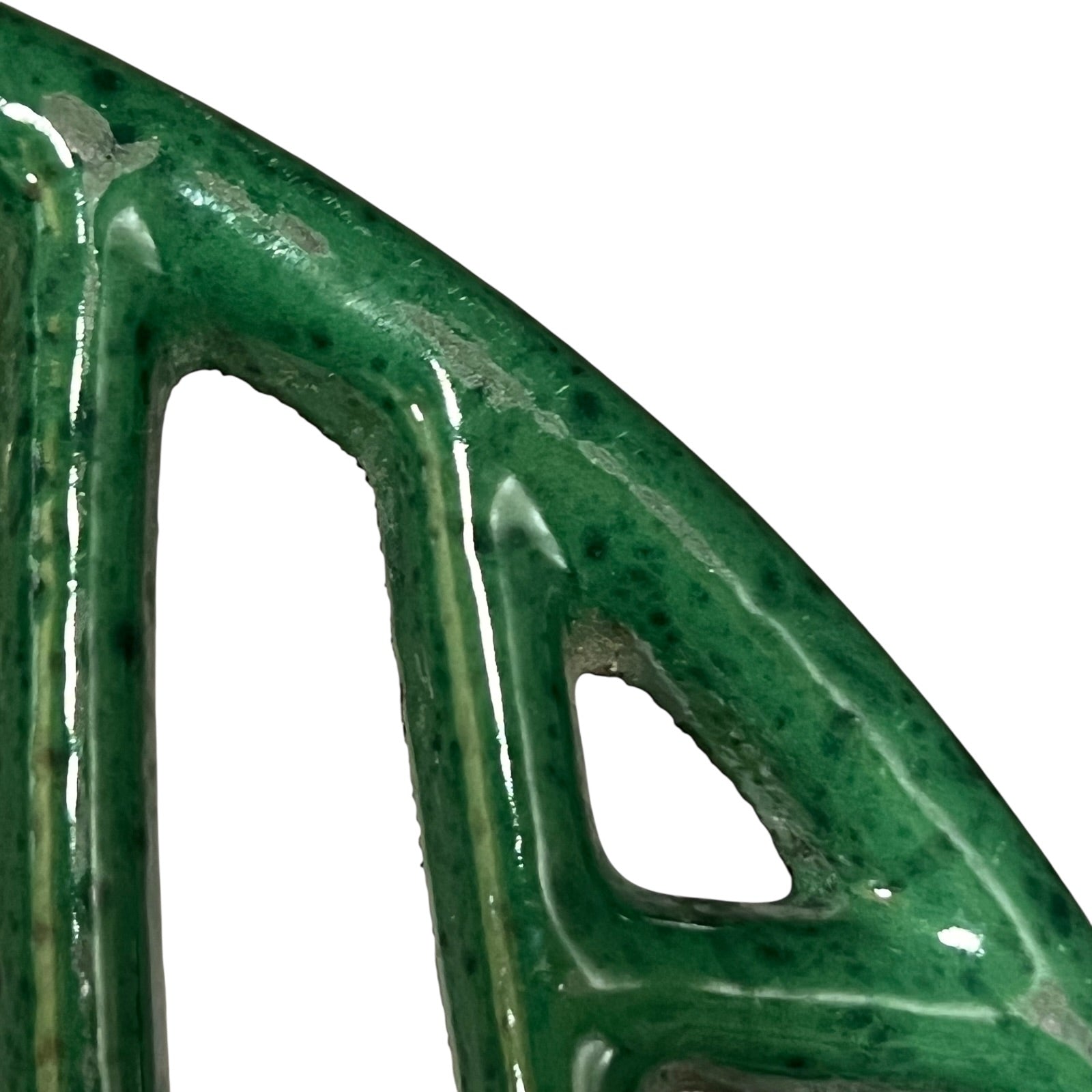 Close up of a green vintage French cast iron enamelled pan trivet on a white background