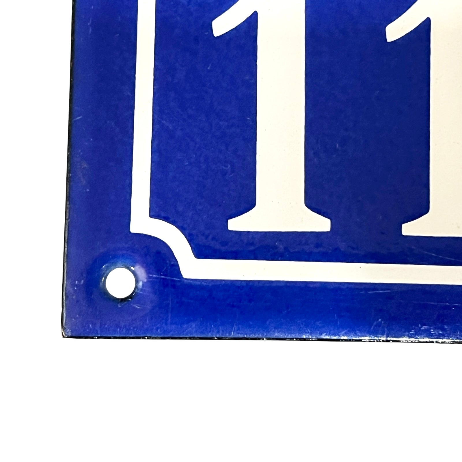Blue and white rectangular sign with number '11'