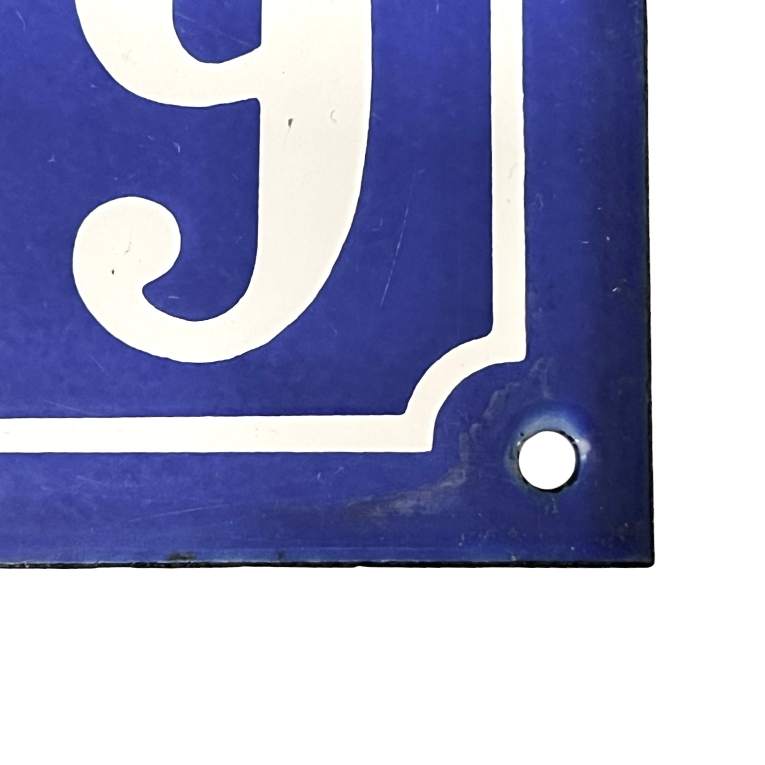 Blue and white number '9' sign with a hole, likely for hanging.
