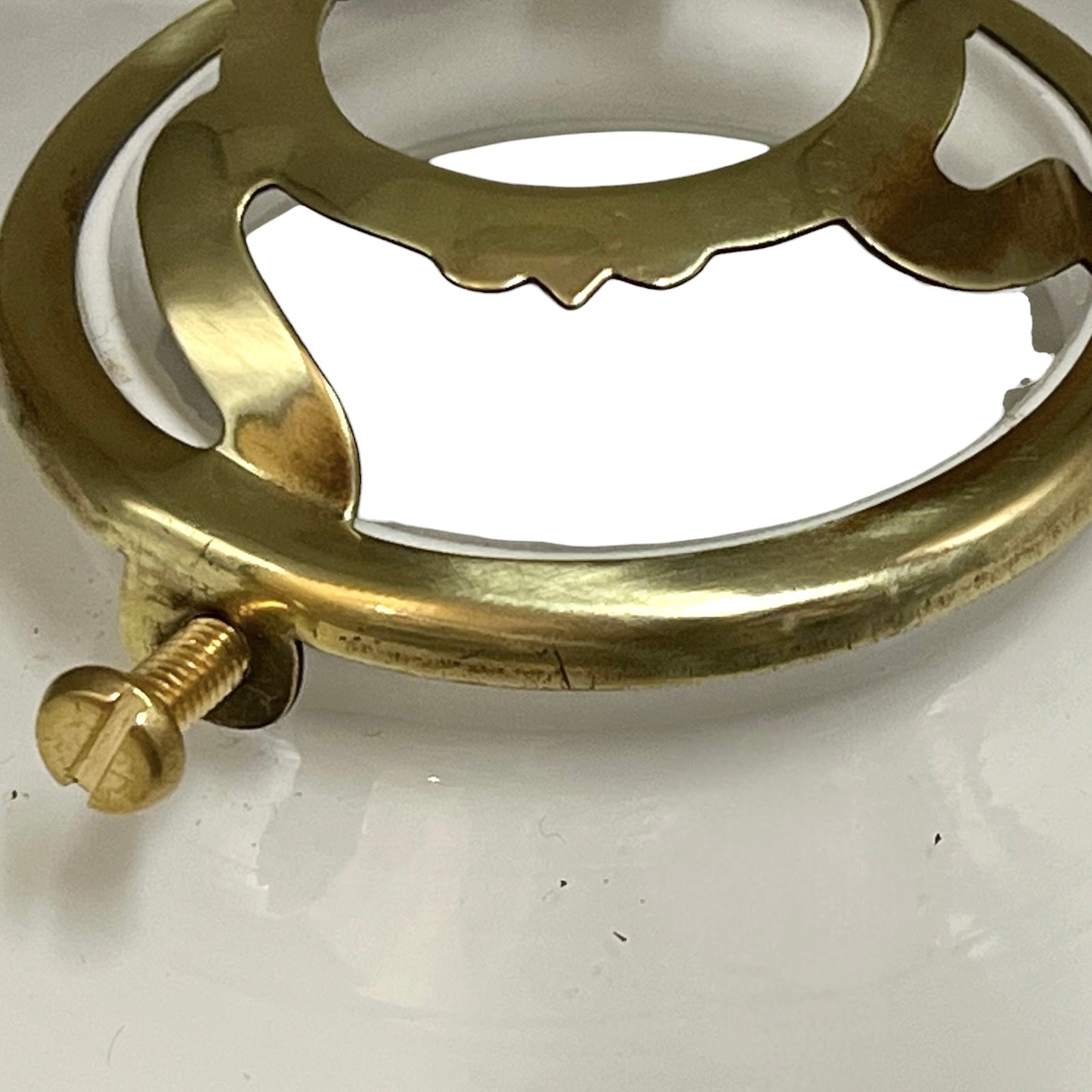 Brass decorative ring with a screw on a white background
