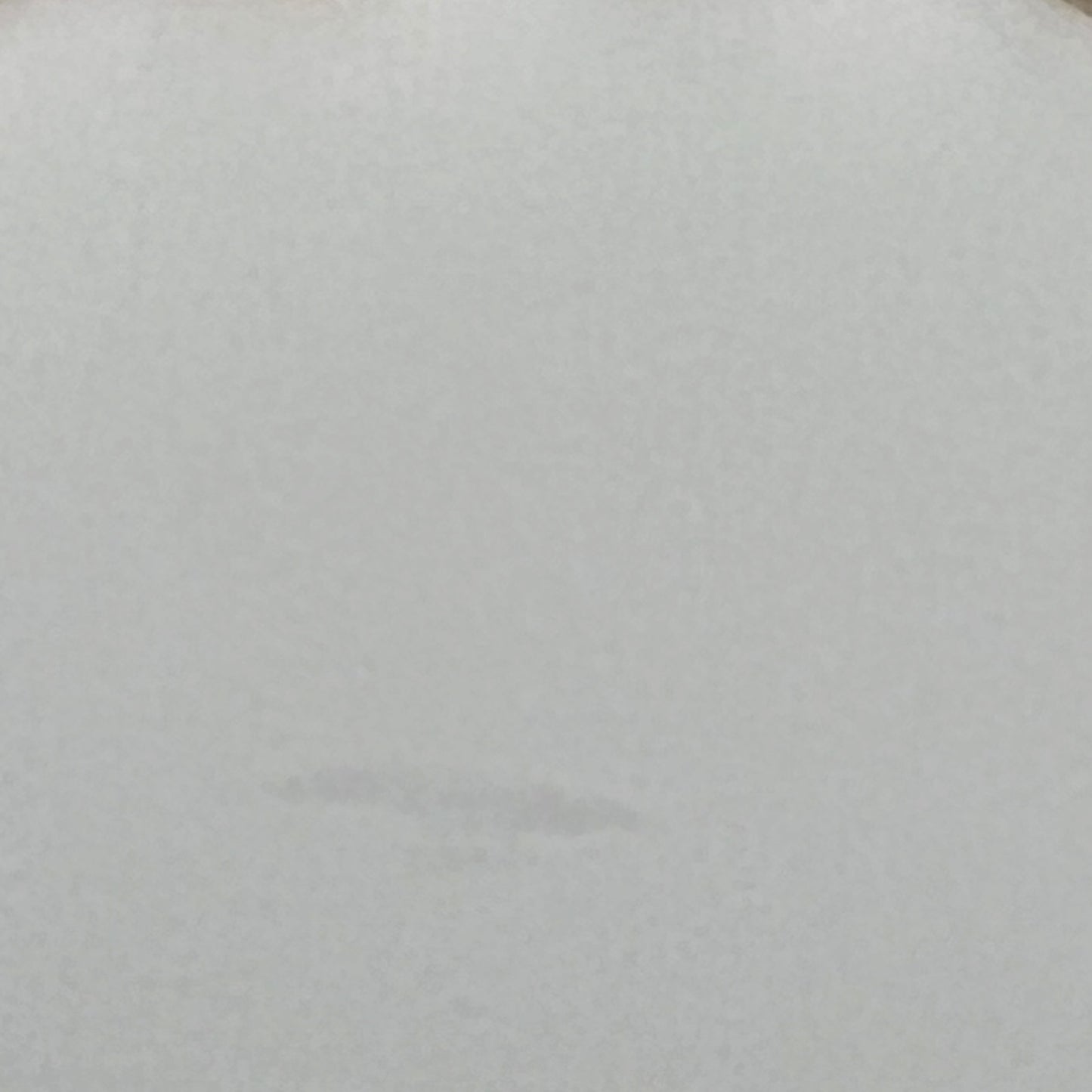 Close-up of a glass lampshade with a decorative edge on a white background