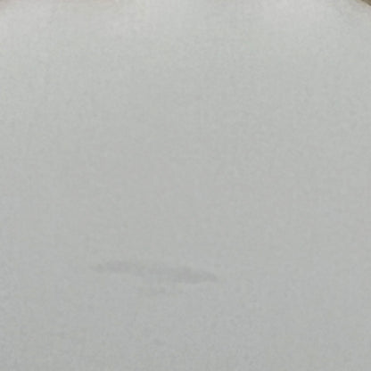 Close-up of a glass lampshade with a decorative edge on a white background