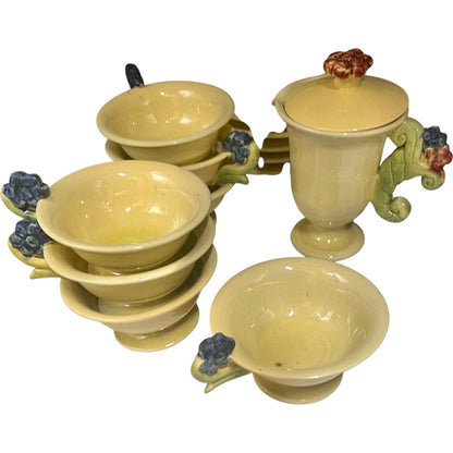 Set of ceramic plates and cups with decorative handles on a white background