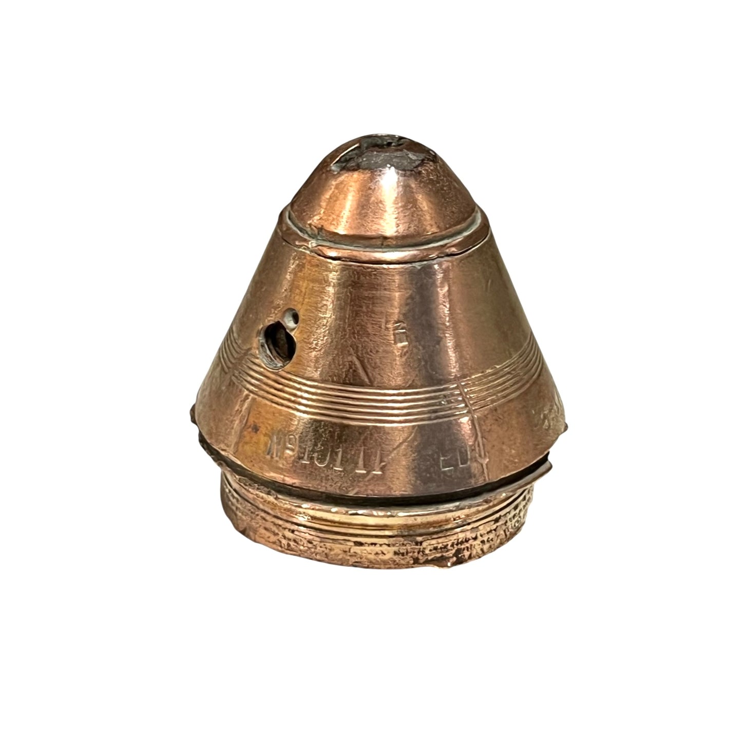WW1 brass fuse paperweight with markings from use on a white background